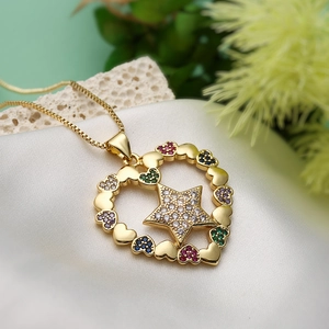 Gold star heart pendant necklace with colorful cubic zirconia on white silk