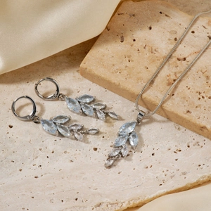 Détail d'un ensemble bijoux argenté avec cristaux bleus en forme de feuilles sur soie
