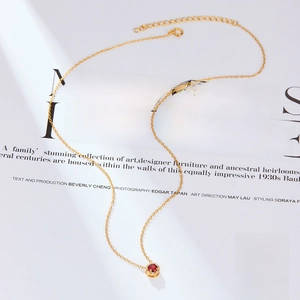 Detail view of 925 silver gold-plated necklace featuring a red zircon pendant