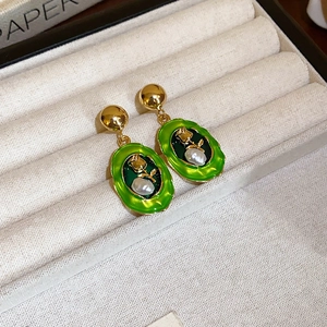 Detail of vintage green enamel earrings with gold rose and baroque pearl inlay