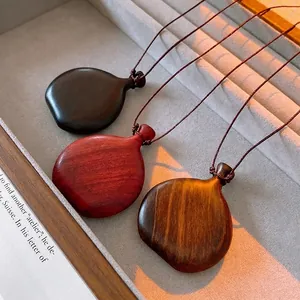 Vintage wooden bottle pendant necklaces in three wood tones on a soft velvet tray