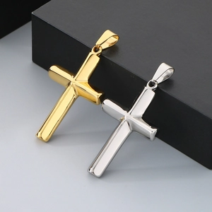 Close-up of polished gold and silver cross pendants in stainless steel with bails