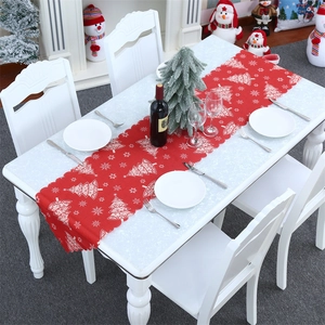 Detail of red Christmas table runner with scalloped edges and white snowflake patterns
