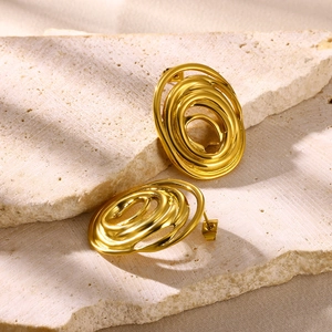 Detailed view of gold spiral flower stud earrings with a textured metallic finish