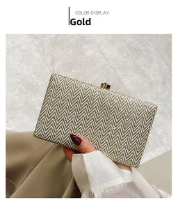 Detailed view of the gold glitter clutch bag featuring elegant wavy texture and gemstone clasp