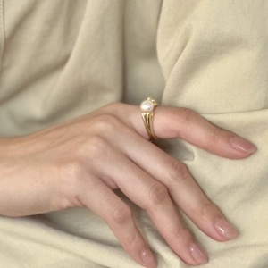 Elegant 925 sterling silver gold ring with a single round white pearl on a woman's hand