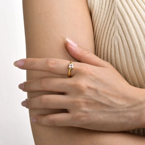 Detail of a gold titanium ring with square zircon on a hand with soft lighting