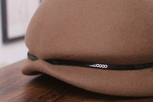 Détail de la texture d'un chapeau cloche en laine avec garniture élégante de paillettes noires