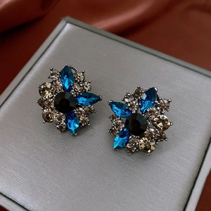 Detail view of vintage flower earrings with blue marquise and black round rhinestones