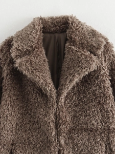 Close-up of brown faux fur coat showing teddy fleece texture and lapel design details