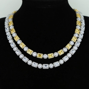 Detail of layered hip hop necklaces with clear and yellow zircon stones on a black bust