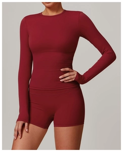 Detail of high-stretch dark red long sleeve yoga top and high waist sports shorts