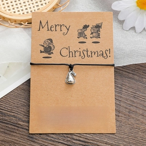 Detail of Christmas wish bracelet with silver Santa hat charm on brown kraft card