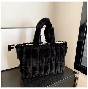 Detailed view of the black plush tote bag featuring elegant vertical stripe textures