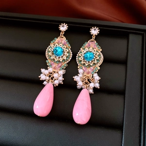 Detail of bohemian drop earrings with blue crystal, faux pearls and pink waterdrop pendant