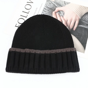 Close-up of black knitted beanie with striped patterns and vertical ribbed texture