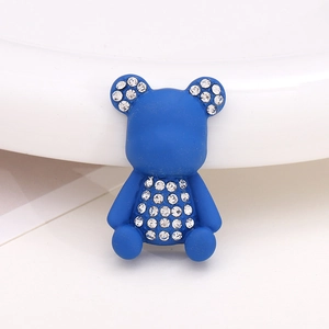 Detail view of a matte blue bear accessory featuring sparkling rhinestone embellishments