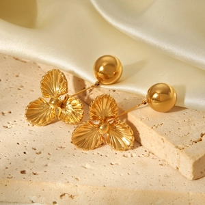 Détail de boucles d'oreilles fleur en acier inoxydable plaqué or 18 carats avec boules