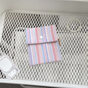 Detailed close-up of striped floral sanitary bag with button closure and brand label