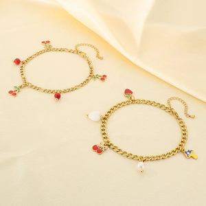 Gros plan détaillé de bracelets de cheville dorés avec cerises et fraises sur satin