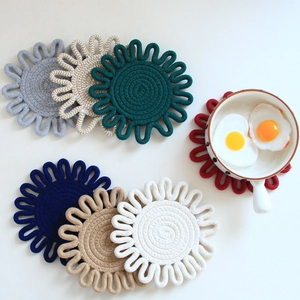 Detail of flower-shaped cotton rope coasters in multiple colors with a bowl on top