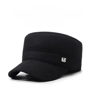 Detail of winter thermal flat top cap with metal logo plate and thick black wool fabric