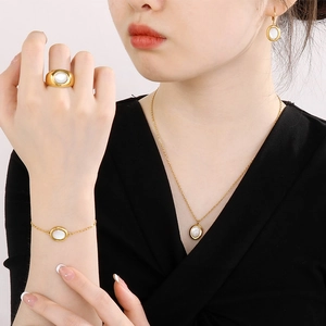 Luxury gold titanium steel jewelry set featuring oval white mother of pearl inlays