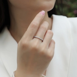 Detailed view of a silver 925 moissanite eternity band ring worn on a female finger