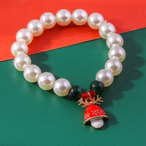 Detail of Christmas pearl bracelet with red enamel bell and golden reindeer antlers