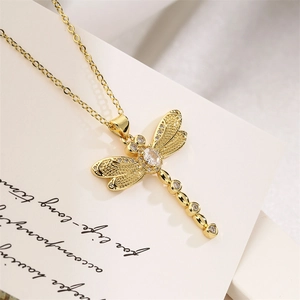 Detailed close-up of a gold dragonfly pendant necklace with sparkling crystal wings