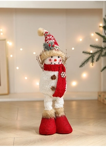 Detailed view of a plush Christmas snowman with a red knit hat and pinecone button accents