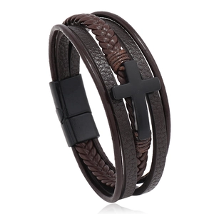 Close-up of multi-layer woven leather bracelet with a black metal cross and magnetic clasp