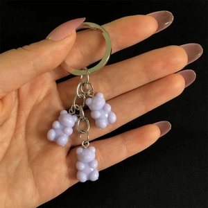 Detailed close-up of glossy purple resin bear charms hanging on a silver metal keychain