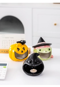 Ceramic Halloween tea light holders featuring pumpkin, witch, and ghost character designs