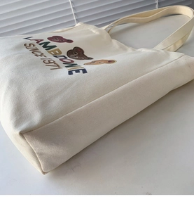 Detailed side view showing the wide three-dimensional base of this large canvas tote bag