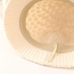 Close-up of beige knitted bucket hat interior with sweatband and adjustable drawstring