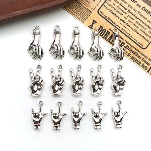 Flat lay of antique silver gesture charms for DIY jewelry making on white background