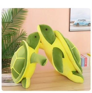 Detail view of large and small green sea turtle plush toys on a wooden table