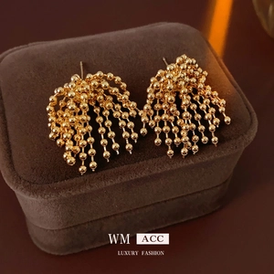 Golden beaded fringe earrings with cascading tassel design on luxury brown velvet box