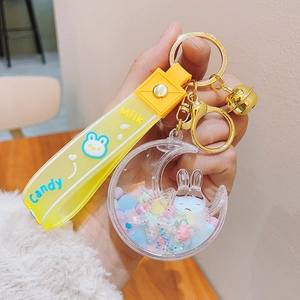 Close-up of crescent moon keychain with colorful beads and white bunny inside