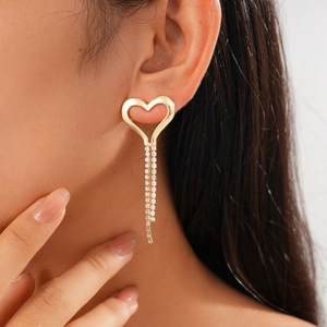 Elegant gold heart earrings with sparkling cubic zirconia tassels on a female model