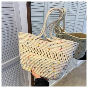 Detail of cream-white woven tote bag featuring colorful polka dots and cotton rope texture