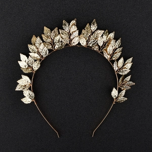Detailed macro view of golden leaf hairband showcasing metallic leaf textures on black base