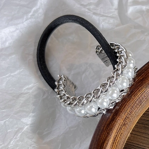 Macro view of elastic hair tie with silver alloy chain and elegant white pearls decoration
