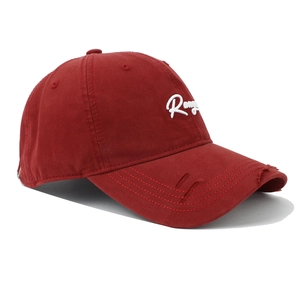 Détail de la casquette rouge foncé en coton vieilli avec broderie blanche et effet déchiré