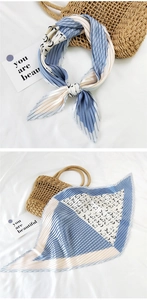 Macro detail of pleated silk scarf with blue and beige color-block pattern