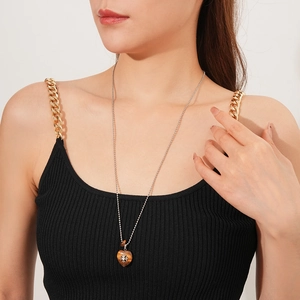 Detail of tiger eye heart pendant with cross inlay on a silver bead chain necklace