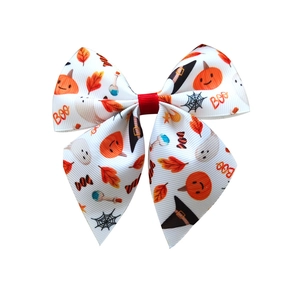 Detail of Halloween hair bow with pumpkin, ghost, and Boo patterns on ribbon