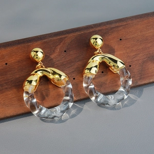 Chic gold stud earrings with transparent resin twisted rings on a textured base