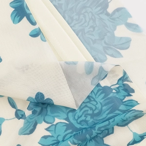 Primer plano de tela de malla floral ligera con elegantes flores azules sobre fondo beige